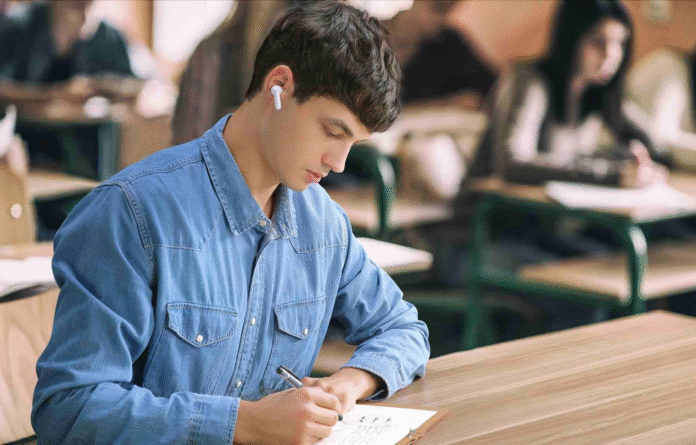 International student using translation earbuds while studying abroad in class.