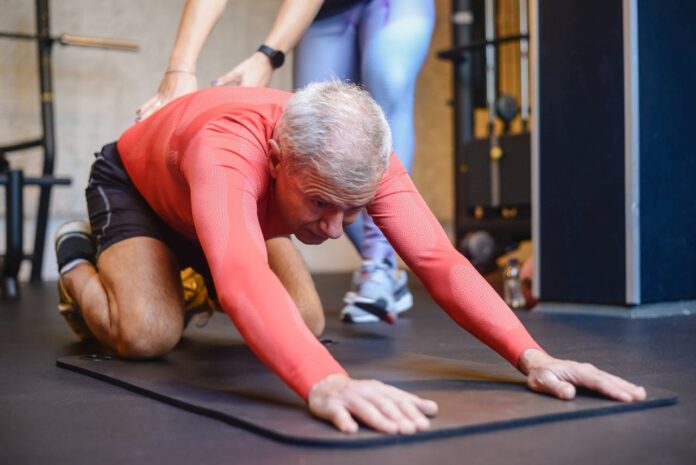 Elderly man stretching outdoors to support joint health and longevity