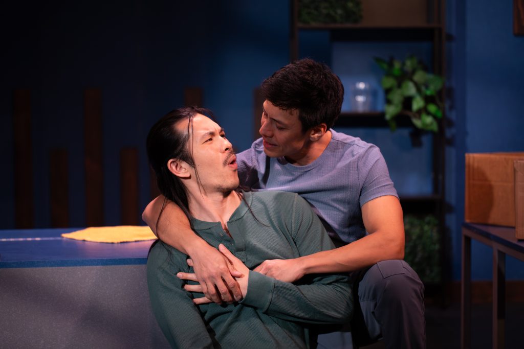 Luca holding Uri during emotional scene on stage