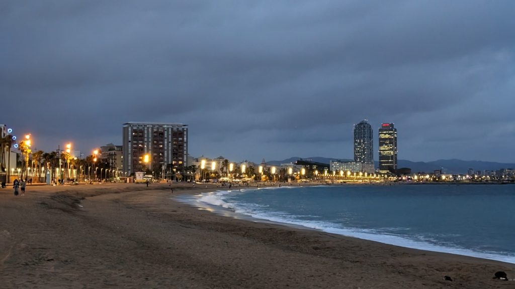 Barcelona beach promenade and skyline along the Mediterranean coast at night