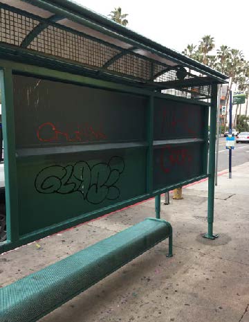 Graffiti vandalism on a North Hollywood bus stop bench and shelter before cleaning in the NoHo Arts District.