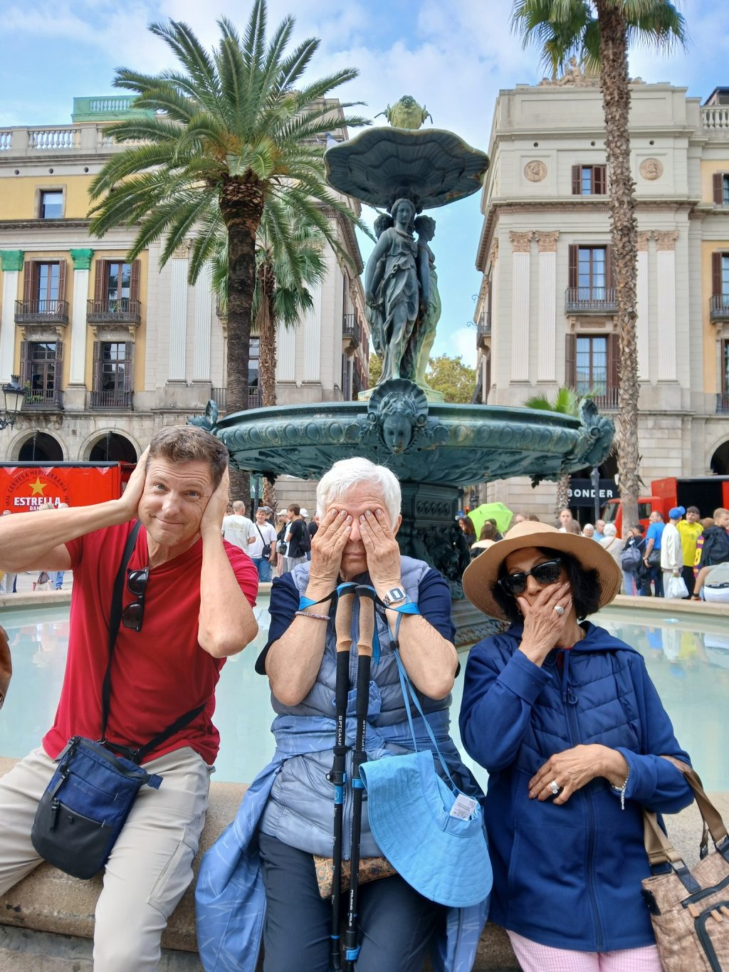 Travelers posing playfully at fountain in Barcelona square