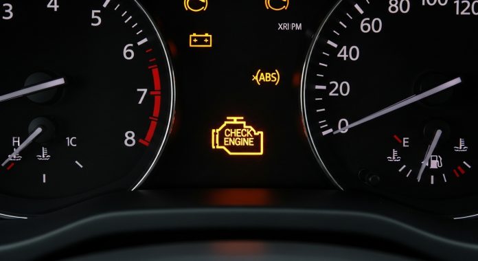 car dashboard check engine light and warning indicators signaling vehicle defect