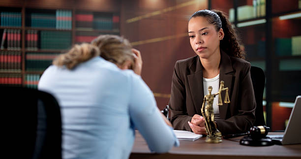 wrongful death lawyer consulting grieving client in office reviewing legal case documents