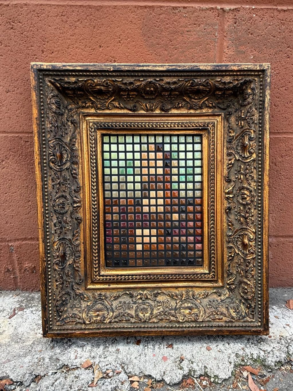 Mona Lisa. Framed 8-bit resin tile artwork displayed against a brick wall with detailed mosaic-style portrait