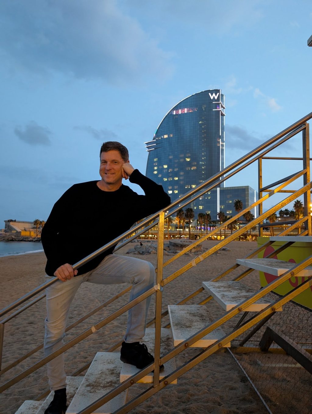 Traveler posing on Barcelona beach near W Hotel at sunset
