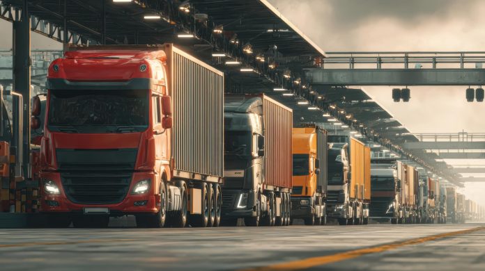 Interstate vs intrastate trucking shown by line of semi trucks at industrial loading dock