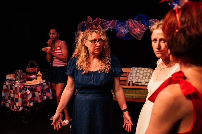 The Baptist Witches of Shelbyville ensemble scene with cast during Fourth of July gathering at Whitefire Theatre