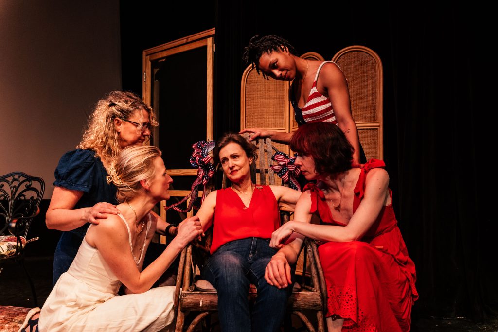 The Baptist Witches of Shelbyville cast gathered around Gigi Bermingham in family scene at Whitefire Theatre