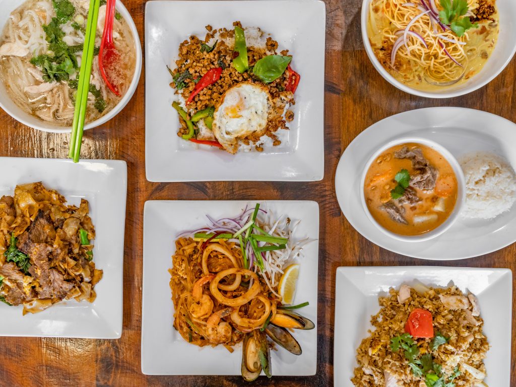 Thai dishes spread including noodles, curry, and fried rice at Delish Thai Kitchen North Hollywood
