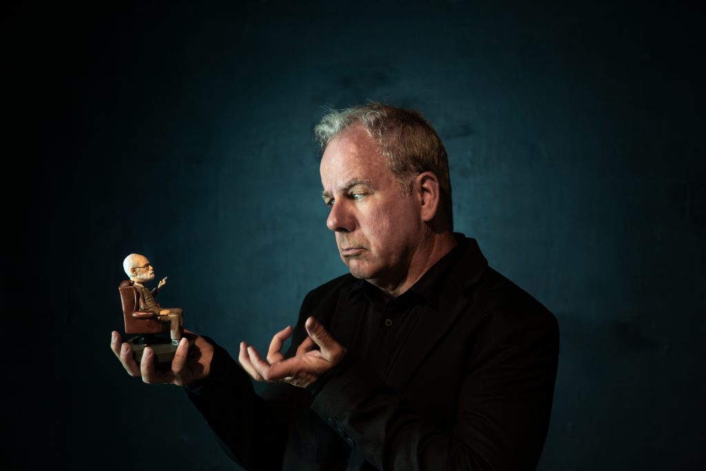 Brian Leonard holding small therapist figurine in Therapist Zero promotional image