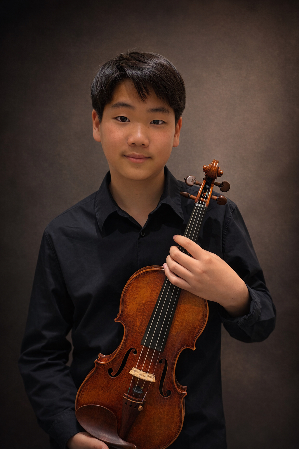 Micah Choi holding a violin in a studio portrait