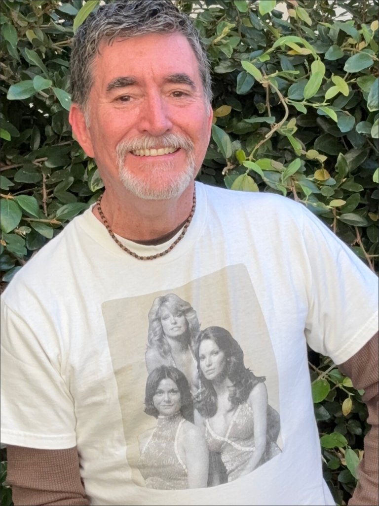 David Pavao portrait wearing Charlie’s Angels shirt for Poster Child solo show Hollywood Fringe Festival