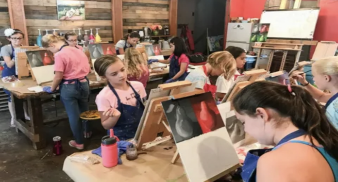 Art classes for kids in Vaughan with children painting at easels in a studio, learning drawing and color techniques in a group setting