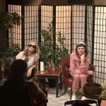 Two actors in a comedic therapy-style scene with folding screens in An Ode to Parenting