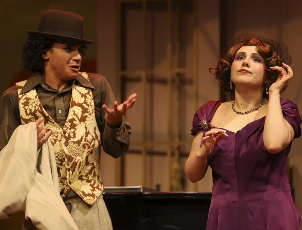 Performer in purple dress and actor in formal vintage costume share comedic dialogue during A Flea in Her Ear at LAPC Theatre