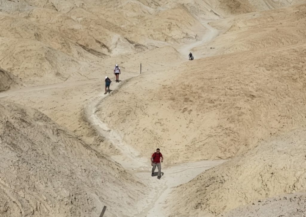 Hikers exploring the Golden Canyon badlands trail in Death Valley National Park.