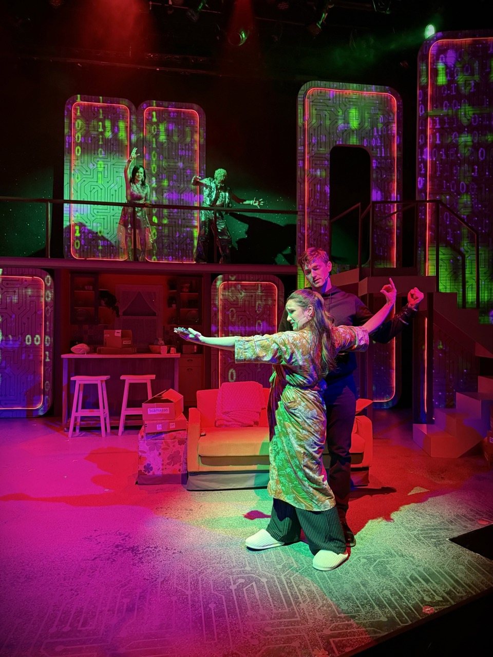 Performers dancing under colorful digital projections in Millennials Are Killing Musicals at The Colony Theatre