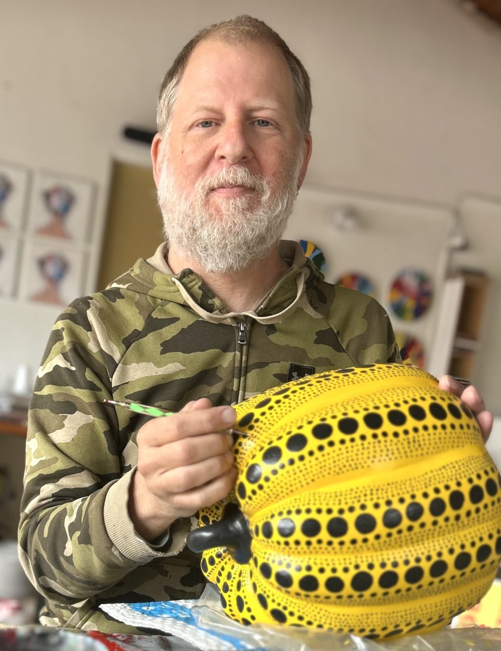 Eric Doeringer hand-painting detail on a Yayoi Kusama-inspired yellow polka dot pumpkin in his NoHo garage studio.