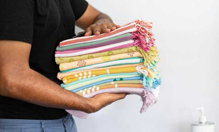 image Person holding a stack of colorful beach towels for a promotional products and event giveaway article.
