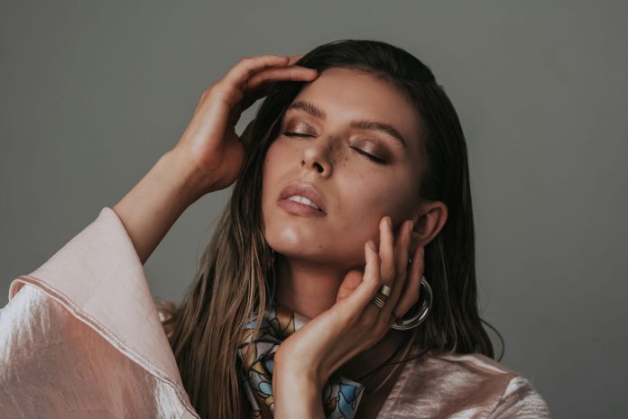 Woman wearing timeless fashion accessories and soft neutral styling representing intentional personal style