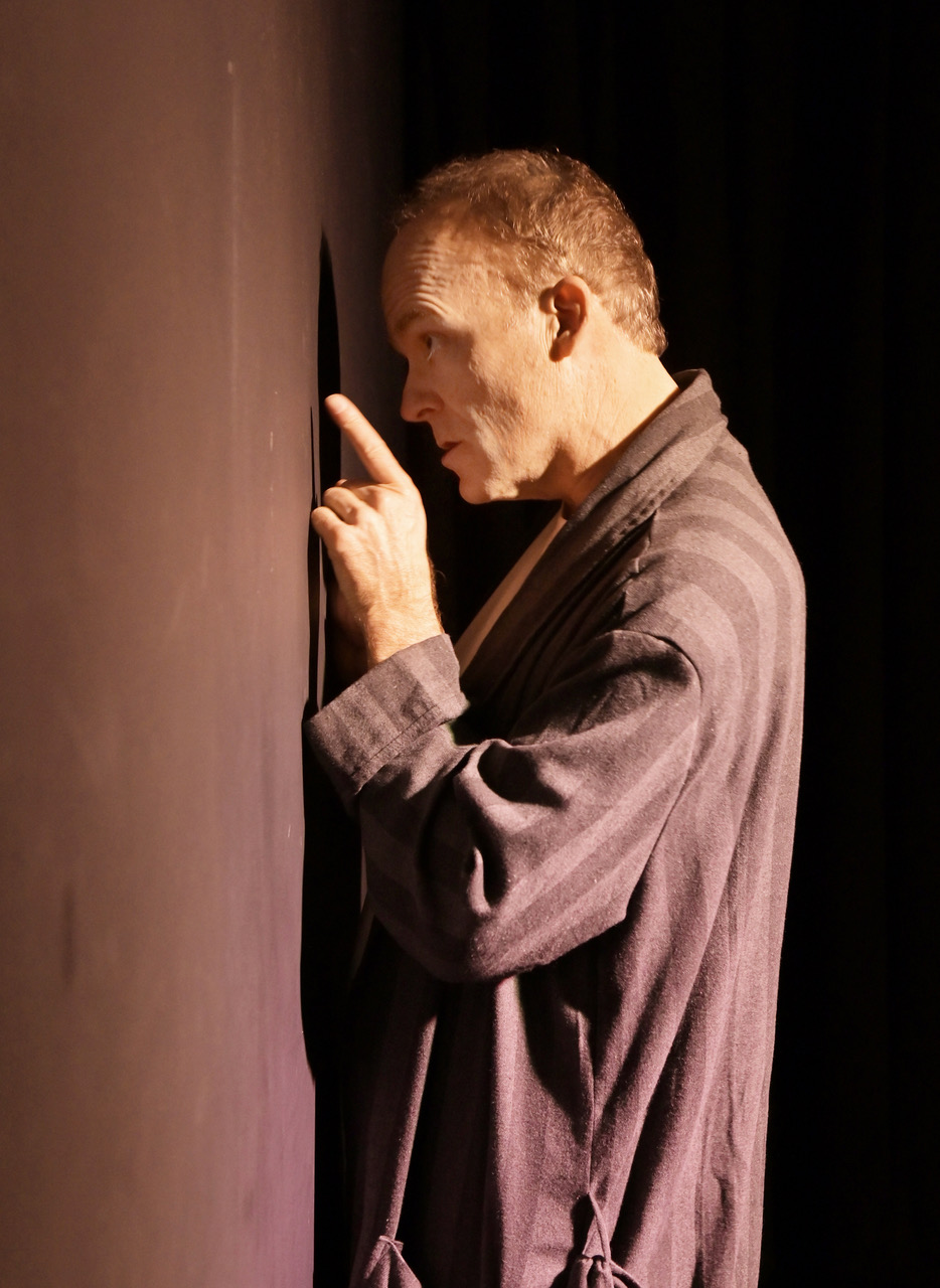 Stefan Marks performs an intimate scene beside a wall in My One Woman Show (The Search for a Truthful Moment) at the 2026 Hollywood Fringe Festival.