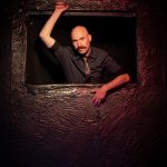 Actor peers through a dark window opening in a scene from Something Anxious: A Double Feature at Hollywood Fringe 2026