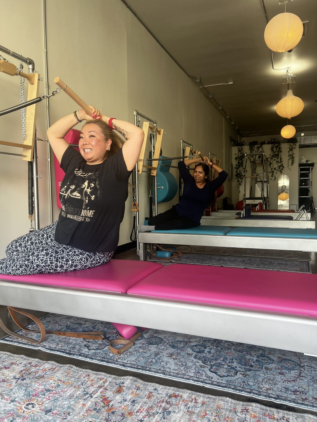 Two clients perform classical Pilates exercises on authentic Gratz reformers during a small-group class at Swan Movement Arts.