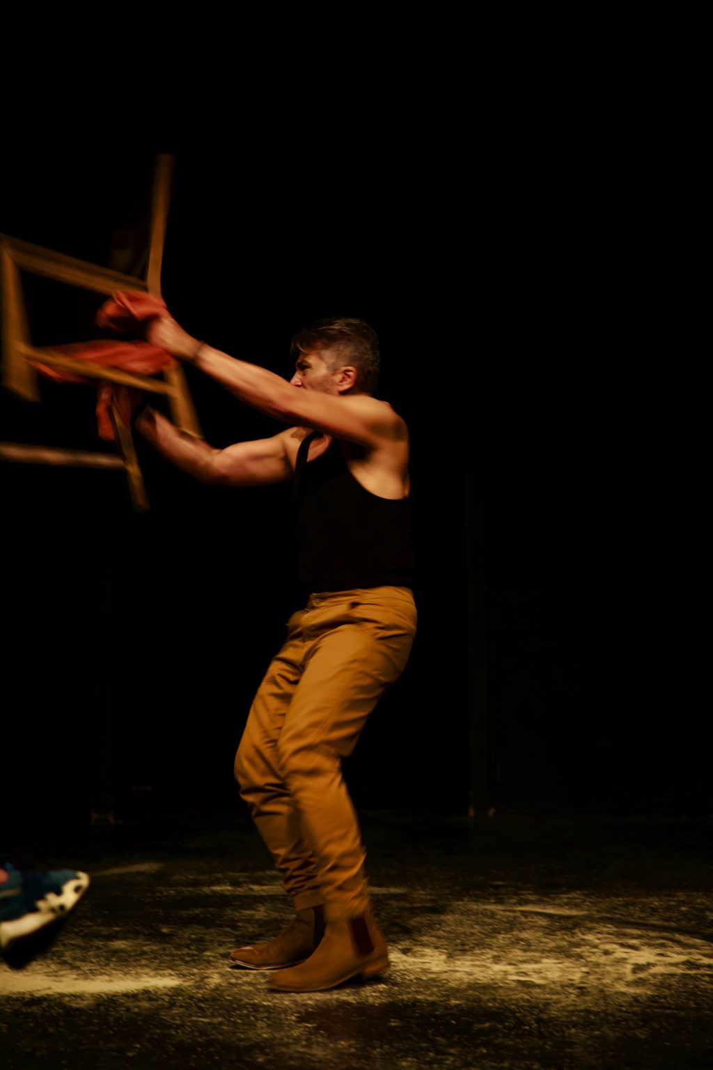 Shahin Sayadi in Ritual Music to Cure a Lover performing with chair on stage surrounded by theatrical smoke and lighting high chair