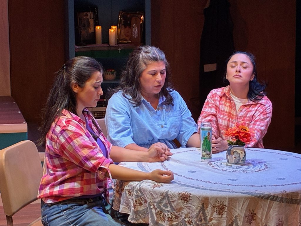 Members of the Flores family pray together during an emotional scene in Soul Sacrifice at CASA 0101 Theatre.