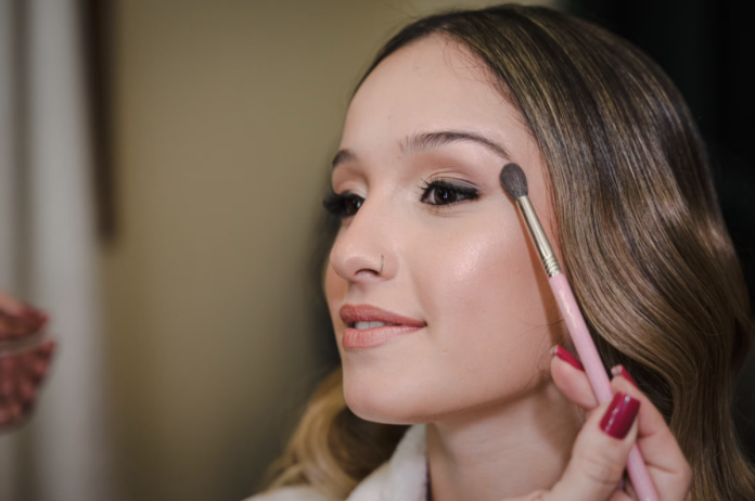 Makeup artist applying eyeshadow to a student model during a professional makeup lesson at a Brampton makeup academy.