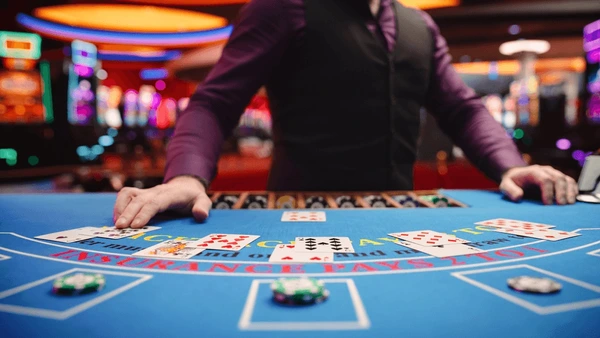 image Dealer dealing cards at a blackjack table inside an online casino, illustrating licensed online blackjack, RNG fairness, casino audits, and regulated gaming.