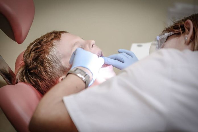 Child receiving a dental examination from a pediatric dentist, illustrating when sedation dentistry for kids may be recommended to reduce dental anxiety and support safe treatment.