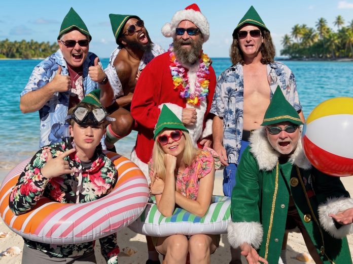 Santasia Summer Show Cast Cast of the Santasia Summer Sing-Along poses in Santa hats, elf costumes, Hawaiian shirts, and beach floats for a Christmas in July celebration.