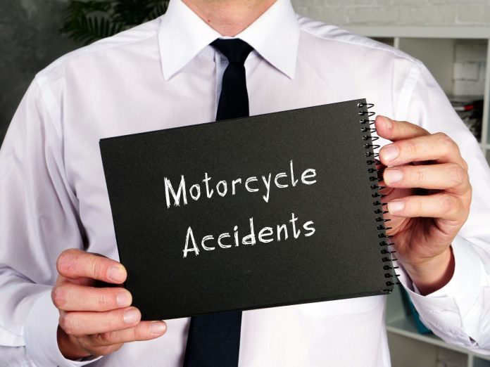 Business professional holding a notebook labeled "Motorcycle Accidents," representing motorcycle accident settlement negotiations and legal claims after a crash.