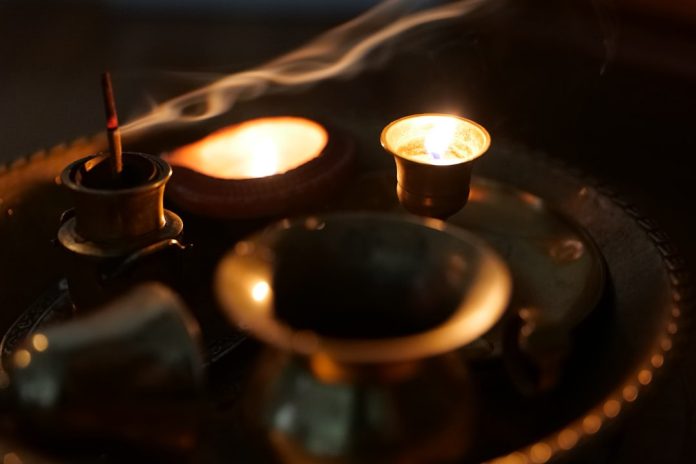 image Candles and traditional ritual items arranged on a tray for a calming evening mindfulness practice.