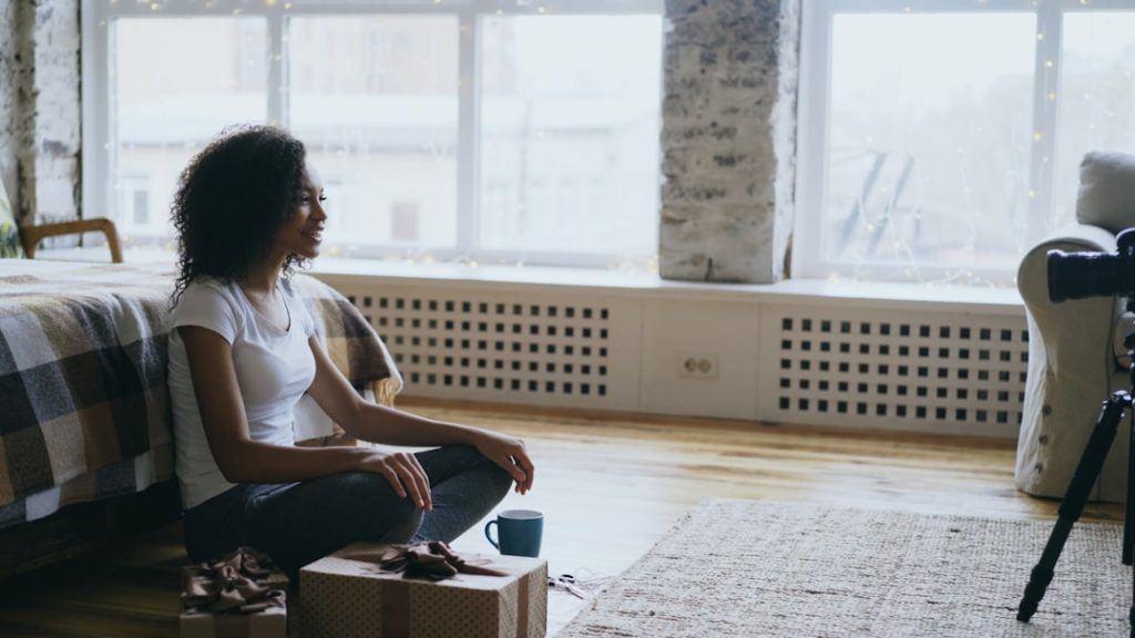 Person sitting cross-legged in a bright living room during a quiet meditation and mindfulness practice.