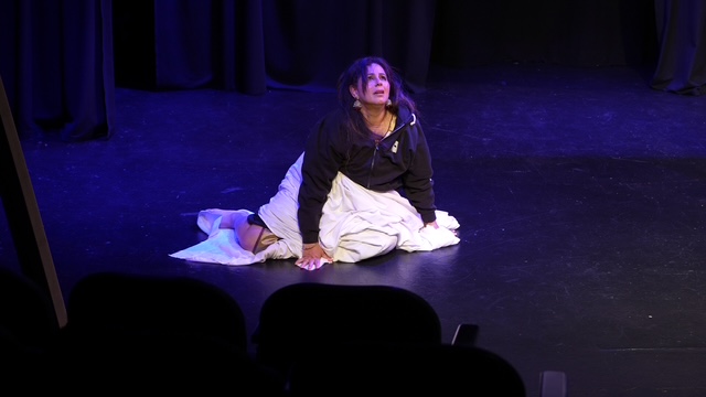 Dr. Dimple Kaur kneels during Split: Between Two Nervous Systems.