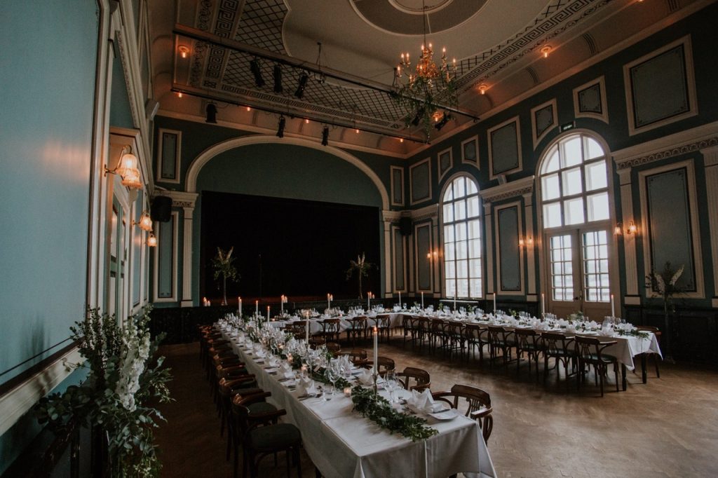 Elegant wedding reception hall transformed with event lighting rental, featuring candlelit banquet tables, chandeliers, uplighting, and a warm, inviting atmosphere.