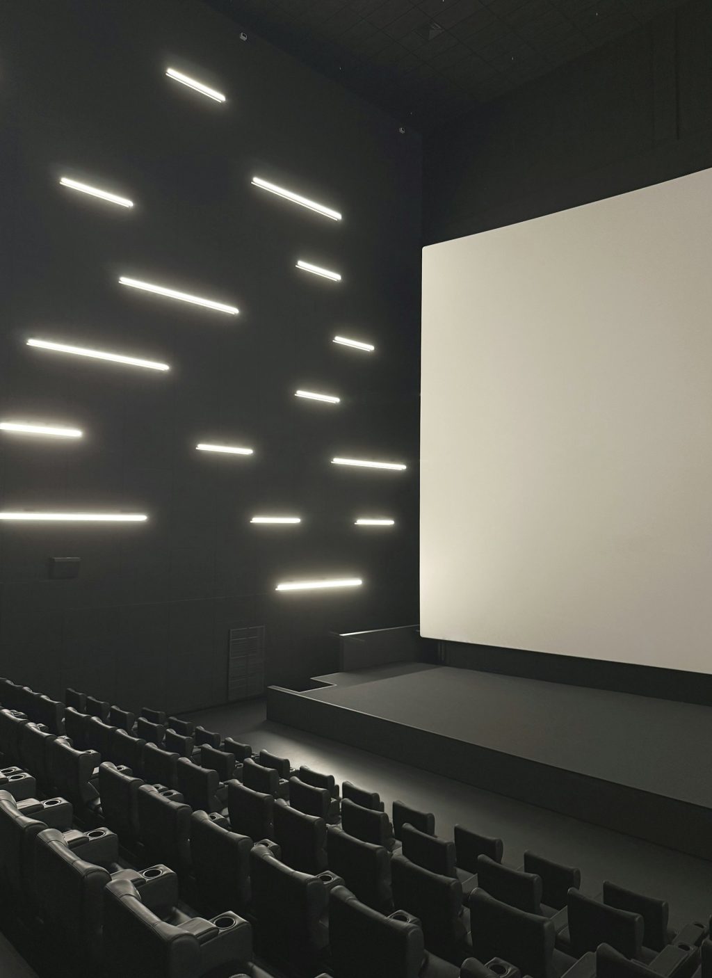 Modern cinema auditorium with a large projection screen and contemporary lighting, illustrating digital cinema technology, secure film distribution, and theatrical presentation.
