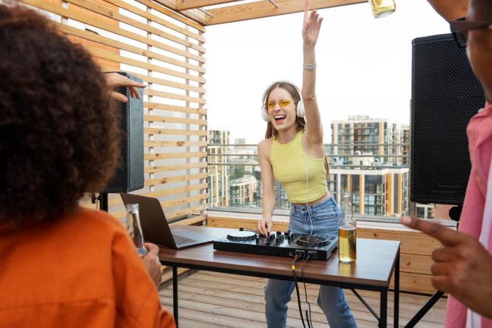 DJ performing at an outdoor rooftop event, representing RØZ, Latin EDM and the duo’s rise from festival stages to their debut album Se Esta Haciendo Tarde.