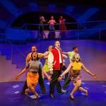 Blake Jenner leads the ensemble in a colorful musical number from Catch Me If You Can at The Colony Theatre.