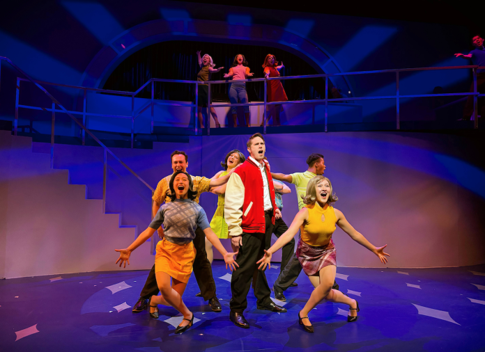 Blake Jenner leads the ensemble in a colorful musical number from Catch Me If You Can at The Colony Theatre.