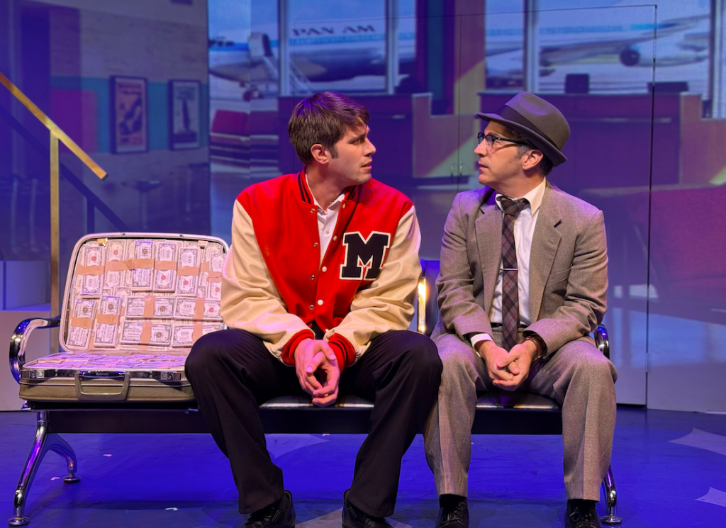 Blake Jenner and Joe Abraham sit beside a suitcase filled with cash in Catch Me If You Can at The Colony Theatre.