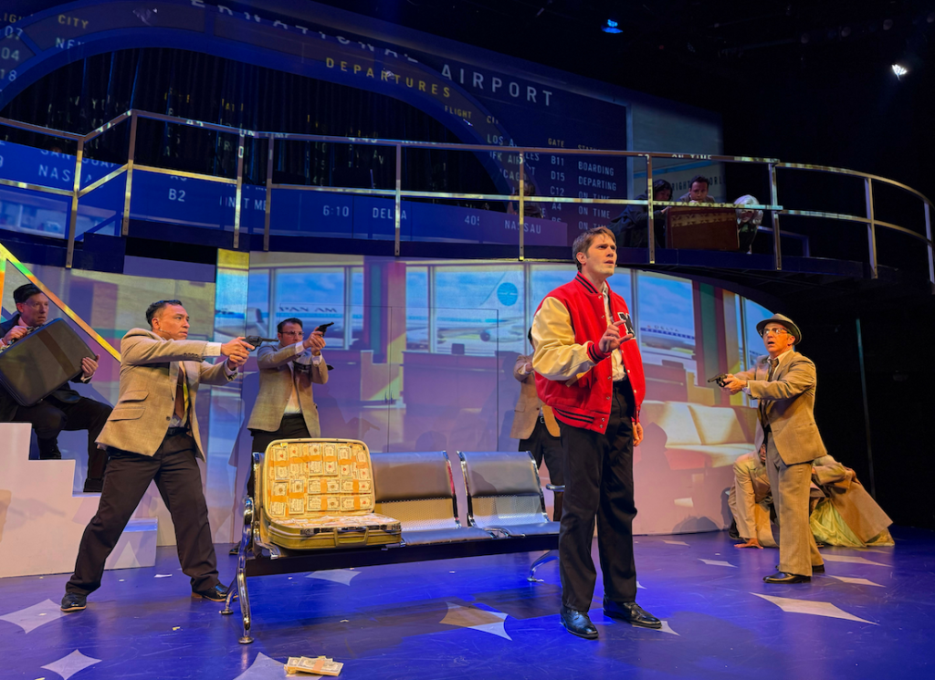 Blake Jenner is surrounded by FBI agents during an airport scene in Catch Me If You Can at The Colony Theatre.