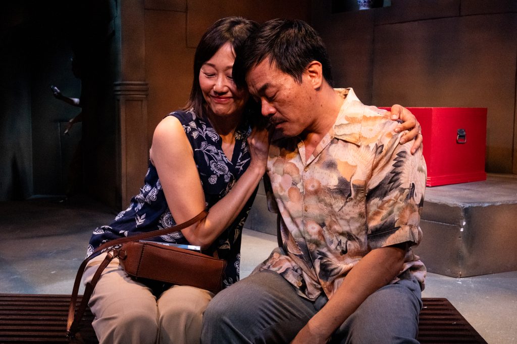 Alt text: Two cast members share an emotional moment in In the Tomb of Ten Thousand Calendars at Moving Arts Theatre.