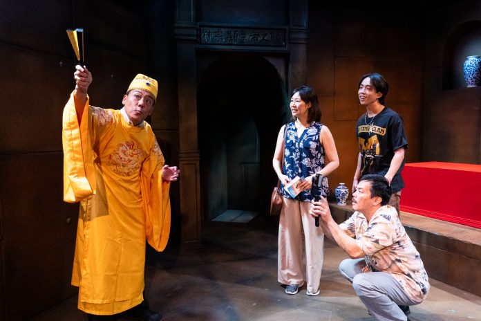 10k--1432 Alt text: Modern-day family touring the emperor’s tomb in In the Tomb of Ten Thousand Calendars at Moving Arts Theatre.