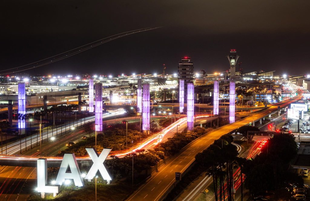 Los Angeles International Airport (LAX) illuminated at night with traffic and airport terminals.