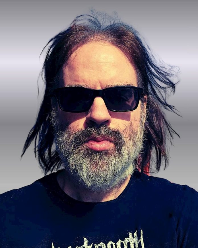 Stephen James Moore of Post Death Soundtrack wearing dark sunglasses in a close-up portrait.