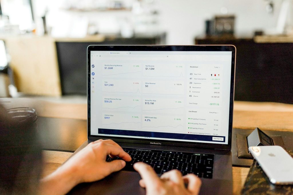 Person using a laptop with a financial dashboard, illustrating open banking and digital payment processing.